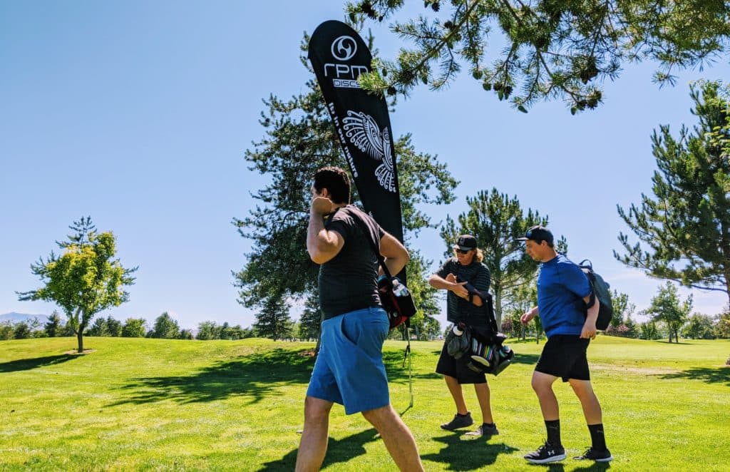Disc golfers walking between baskets in 2025