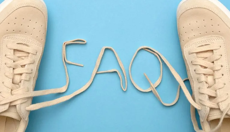A pair of beige sneakers with their laces forming the word FAQ on a blue background.